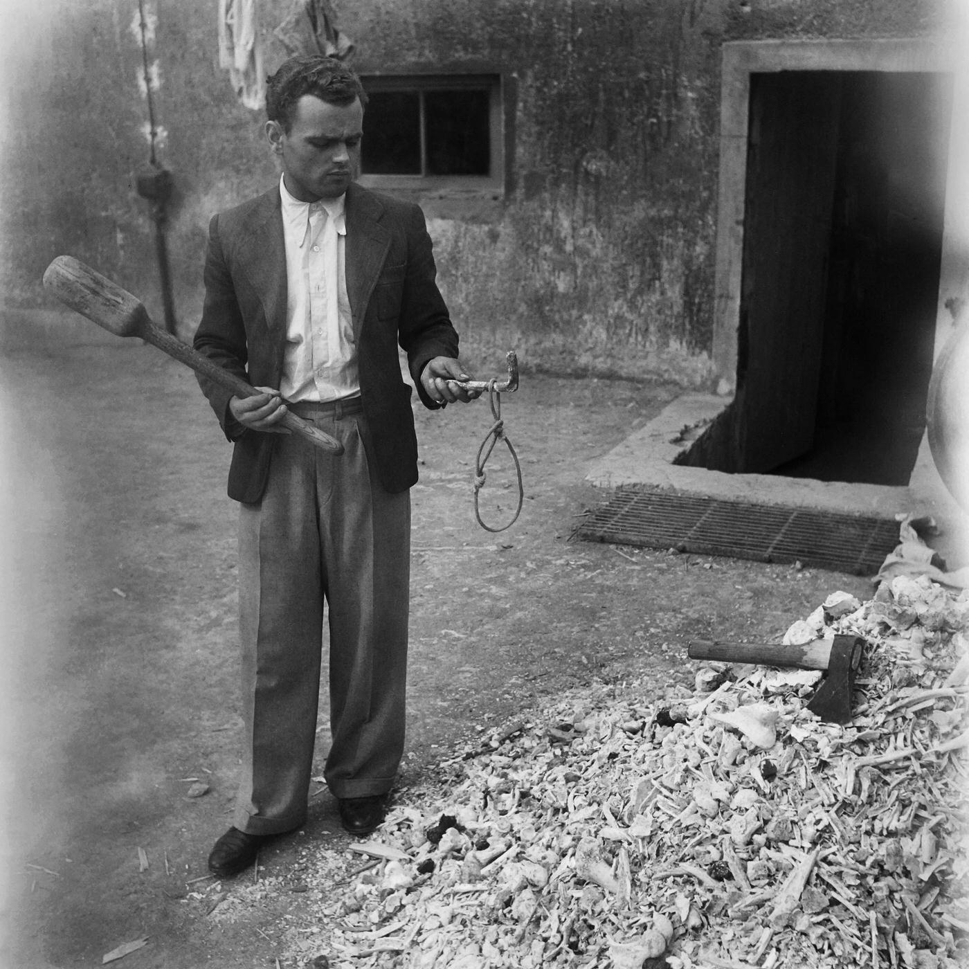 #22 A man shows a noose used for hanging in Buchenwald concentration camp in April 1945.