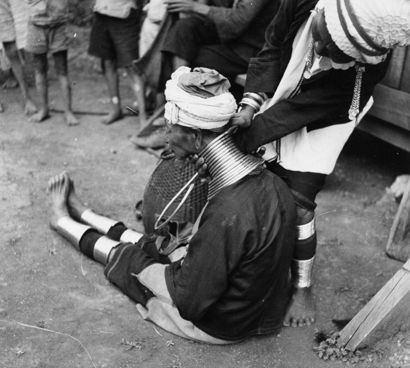 #15 A Padaung woman getting a new brass ring fitted around her neck, Burma, 1950.