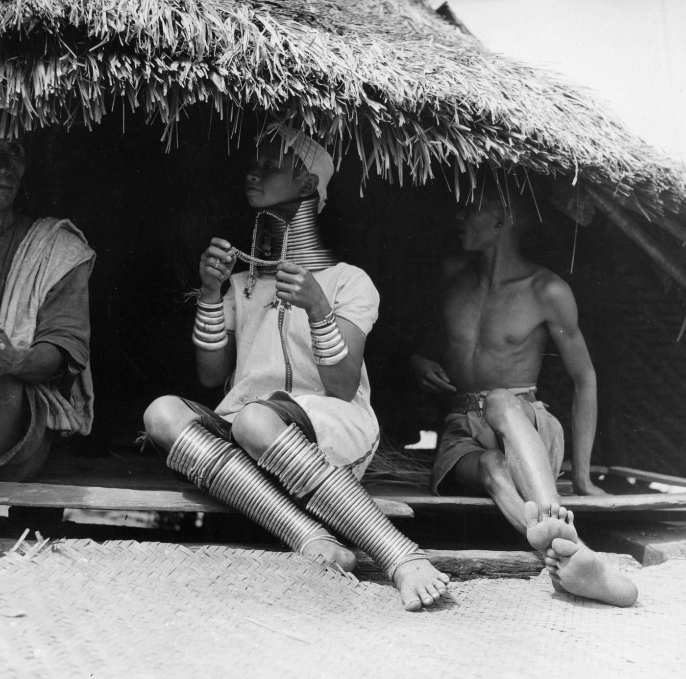 #16 Group of Padaung, or Kayan people, sitting in a hut, Burma, 1950.