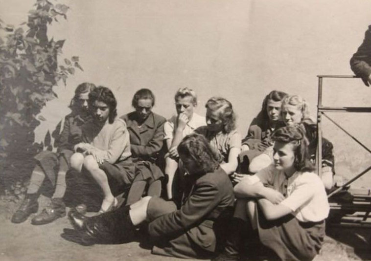 #5 A group of young women sit outside the jail where 45 people faced charges for war crimes in 1945.