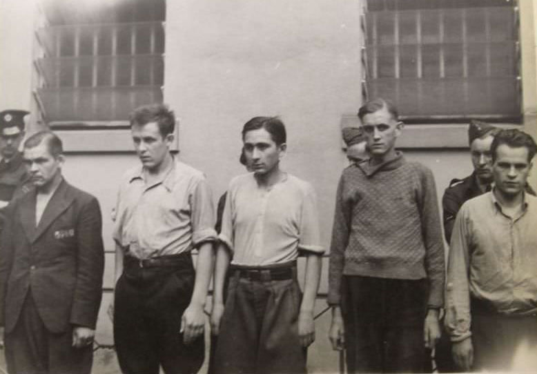 #7 A group of unidentified prisoners are lined up against a wall during their detainment at Celle Prison, in Germany.