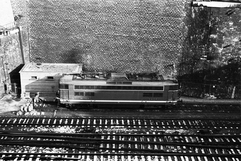 #12 Commuter service at Gare St. Lazare. Relief locomotive stands by near terminal throat, Paris, December 1969