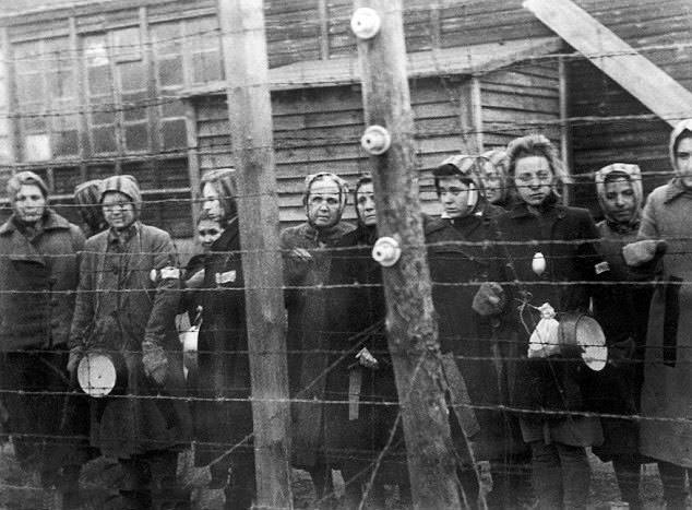 #3 Prisoners at Ravensbrück concentration camp in Germany stand near barbed wire in 1945