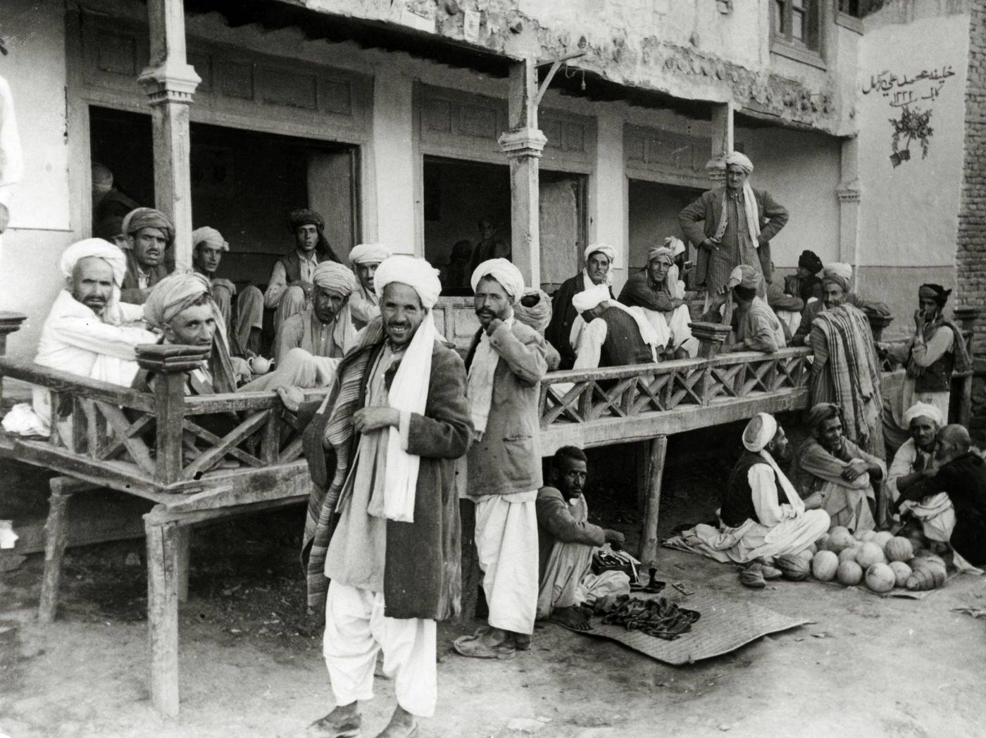 #39 Kabul street scene with guests passing the time on a verandah, circa 1950.