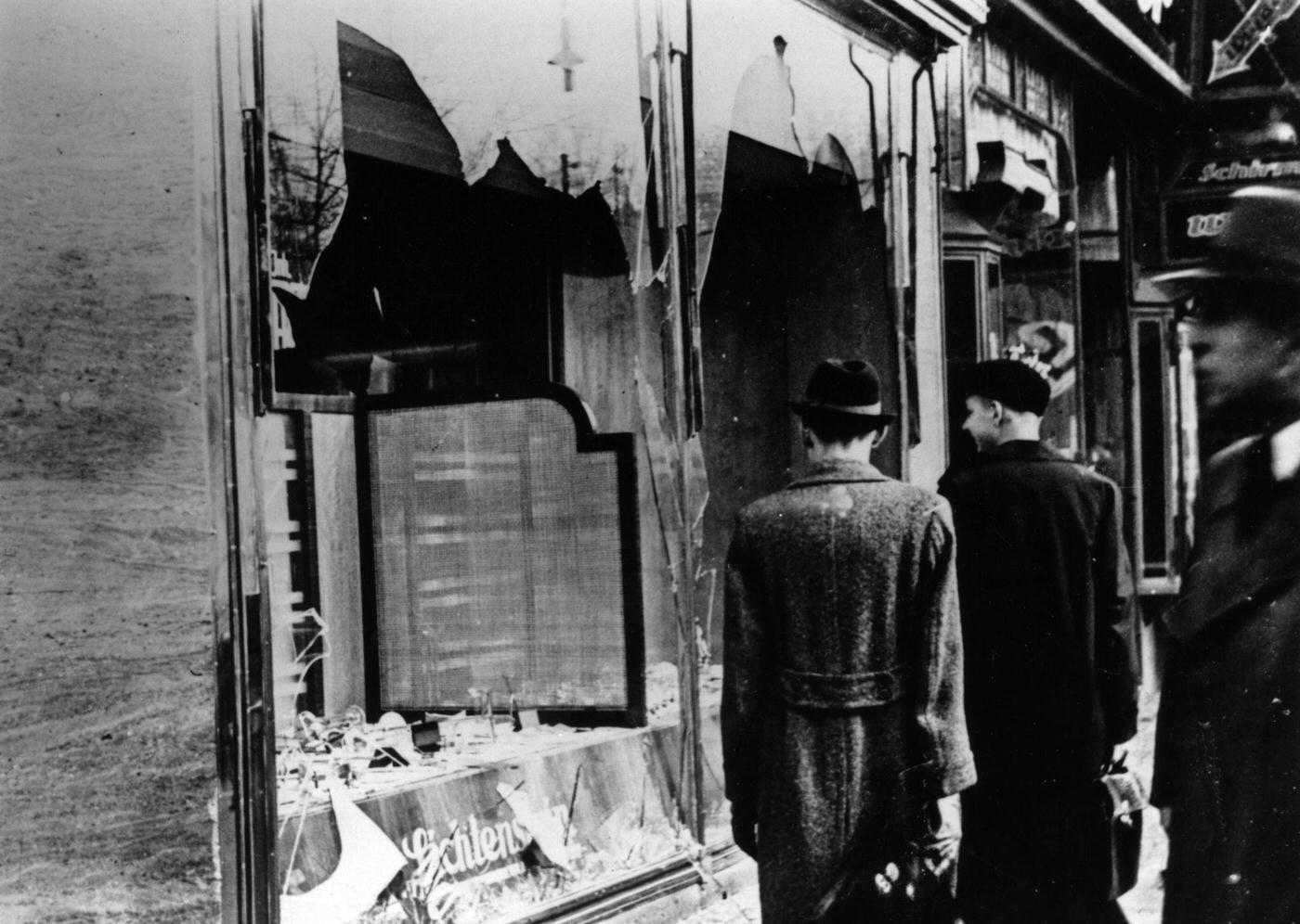 #44 Onlookers at a smashed Jewish shop window in Berlin after Kristallnacht, November 1938.
