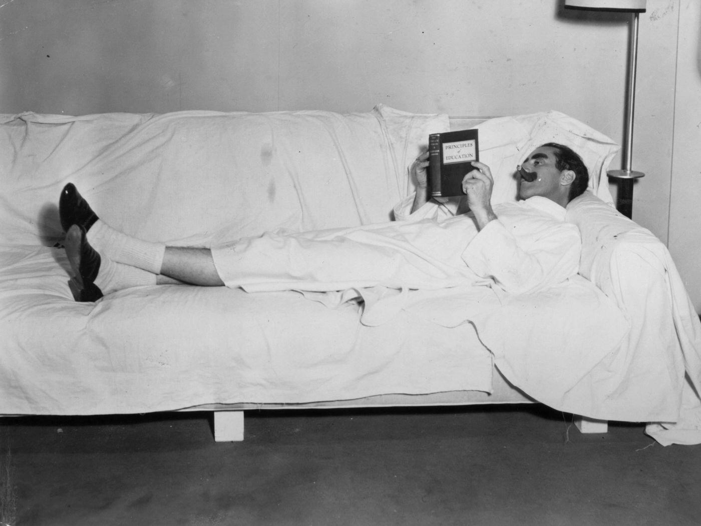 Groucho Marx takes a break while filming Duck Soup (1933), reading “Principals of Education.”