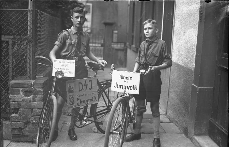#41 Members of the Hitler Youth with party slogan on display on their bicycles, Worms, Germany, 1930s.