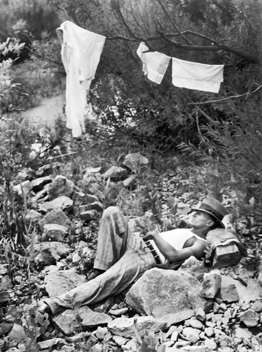 #67 A man napped on Cherry Isle in the James River in Richmond while his clothes and belongings dried on a line, 1937.