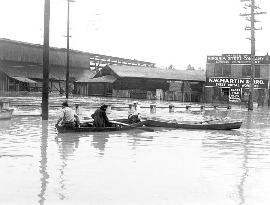 #72 Three men used small rowboats to navigate over a submerged bridge at 17th and Dock streets in Richmond, 1935.