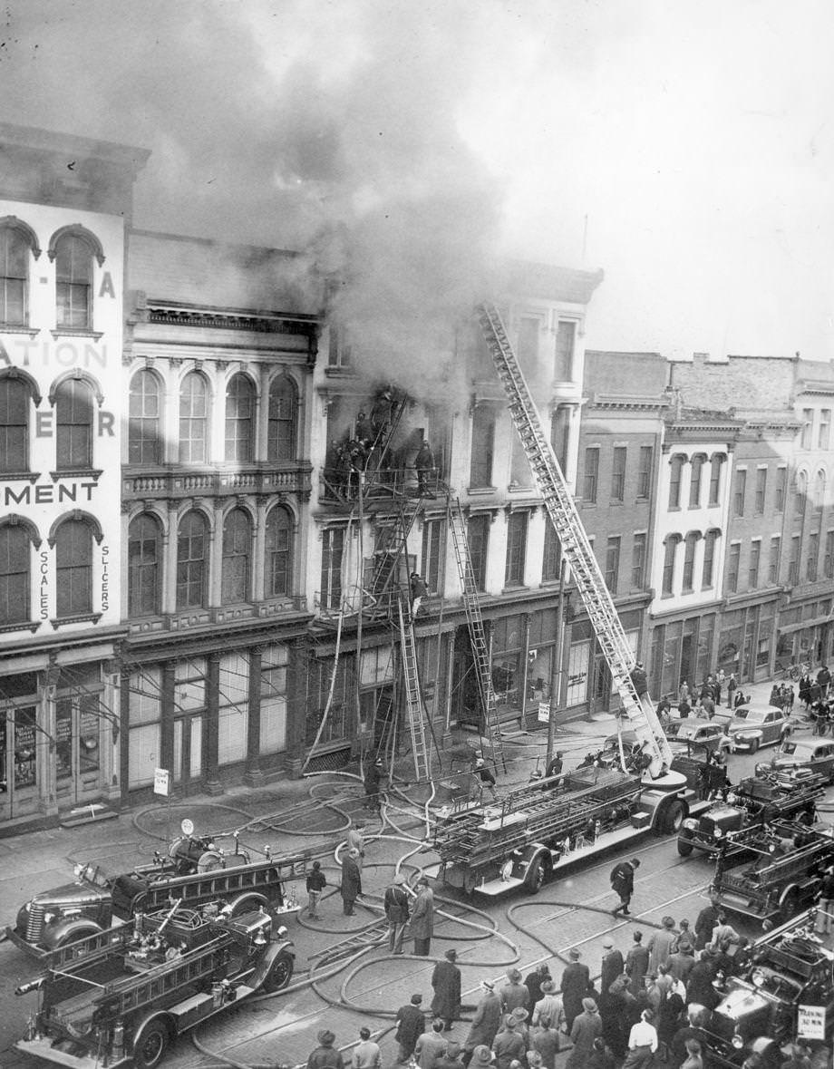 #108 Rush hour crowd watches smoke pour from building at 14th and Main during fire, 1948.