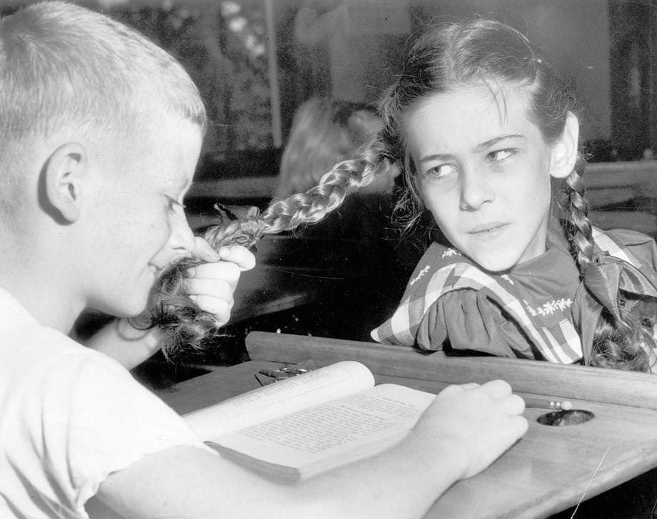 #191 As the school year started, Dick Harvey gave a playful tug to Sue Gallegher’s pigtails, 1948.