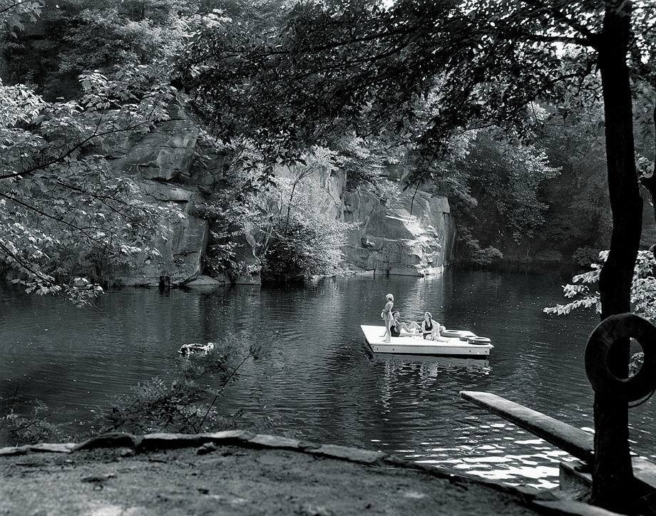 #91 Women lounged on a floating platform at a swimming hole that was once a quarry, 1950.