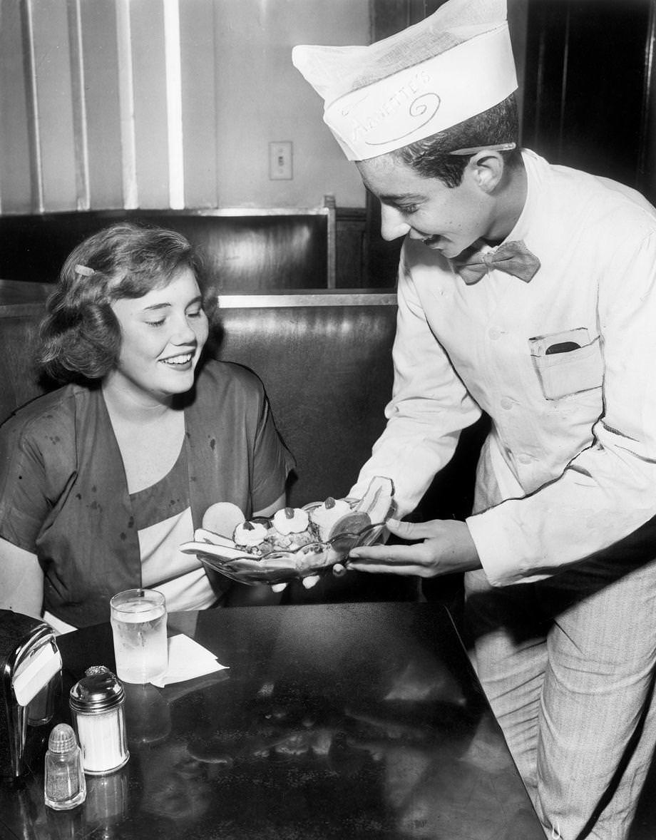 #43 A curb boy at Arnette’s Ice Cream Co., served Beverly Page French a banana split, 1950. T