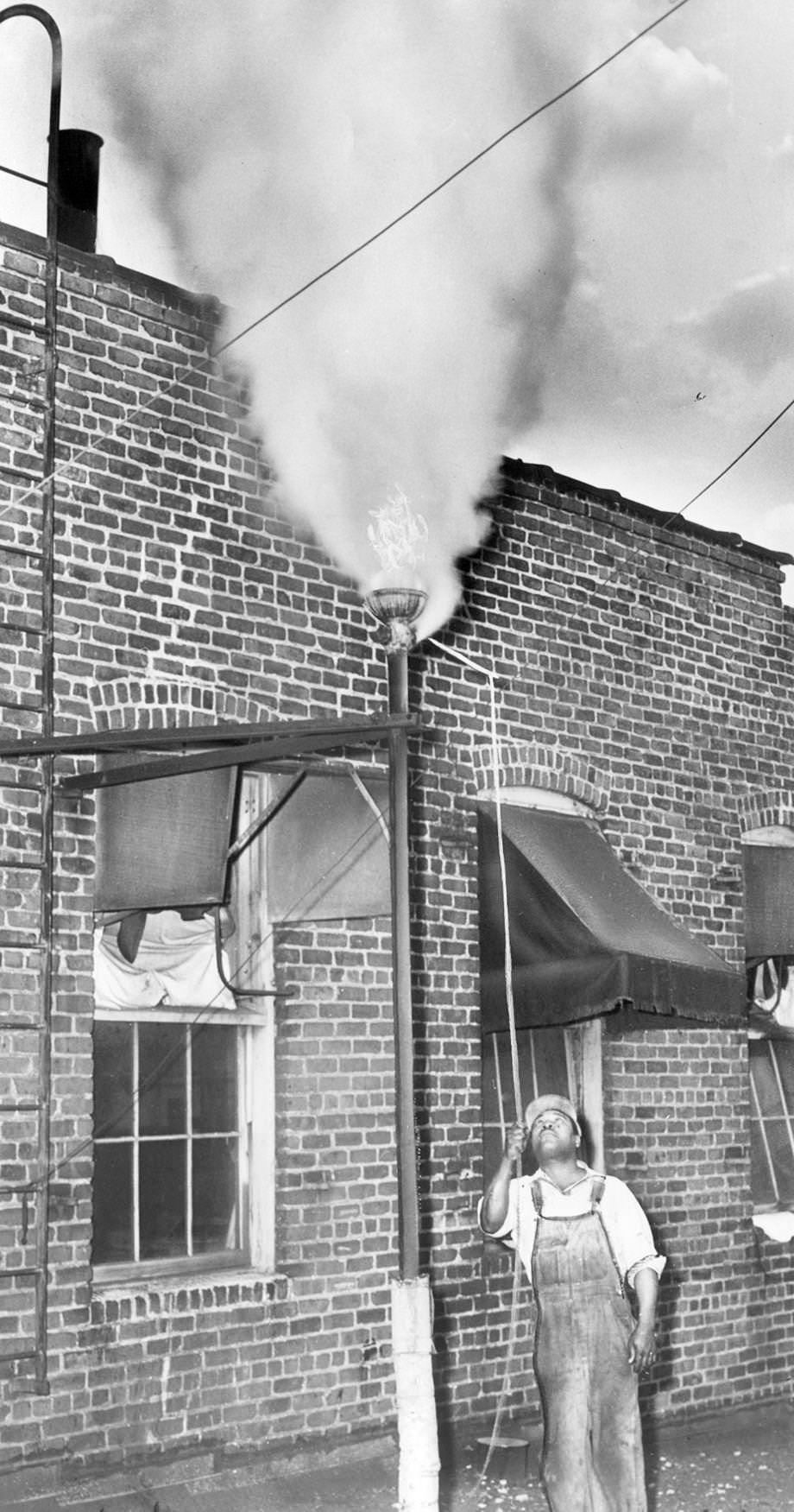 #73 Roman West pulled the cord of a steam whistle at T&E Laundry on Marshall Street in Richmond, 1951.