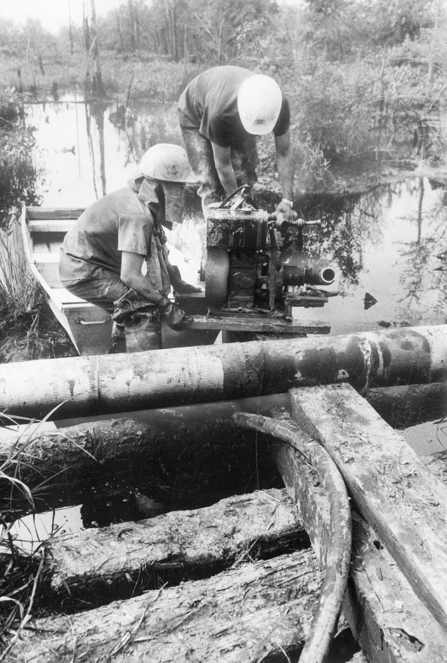 #83 A cleanup crew from Norfolk worked on an oil spill in South Richmond. Fuel oil had escaped from an open valve at Little Oil Co. on Commerce Road, 1975.