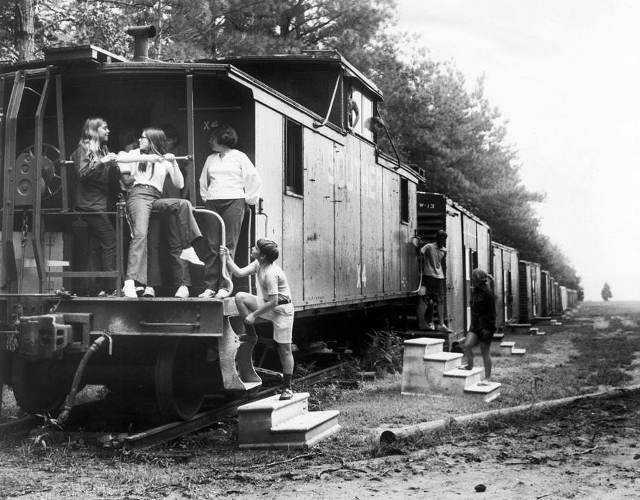 #134 Members of Camp Willow Run gathered outside their dormitories, which were former train boxcars, 1971.