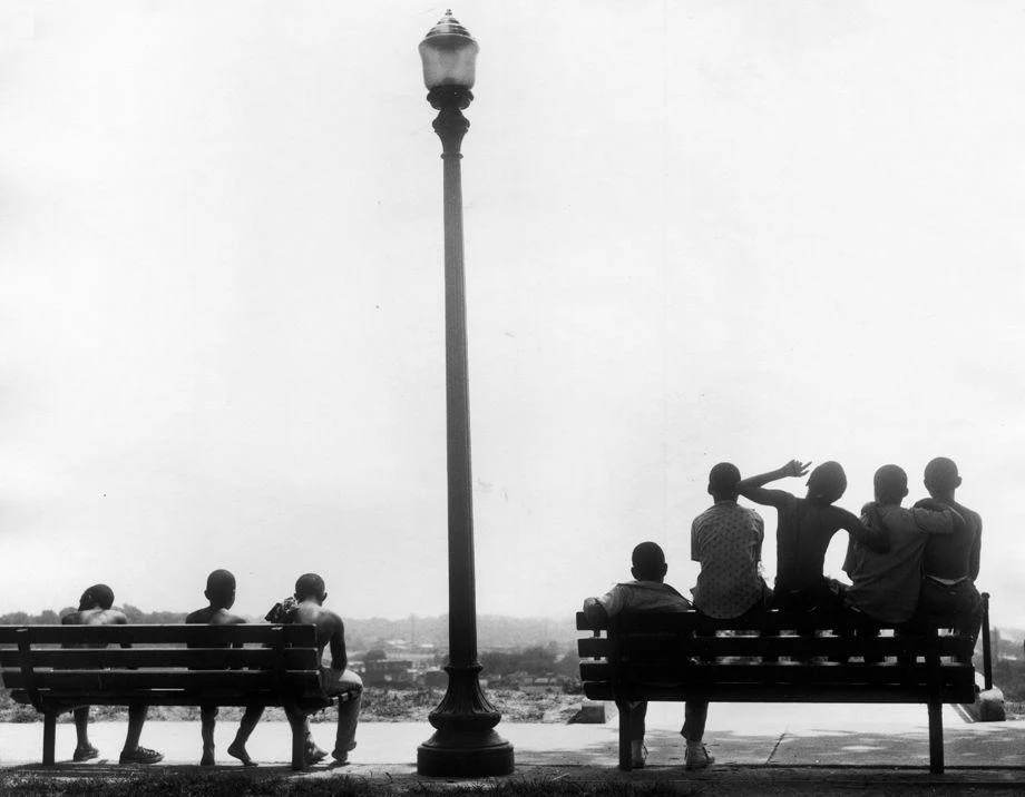 #173 A group of children took a break from playing and sat on the bench at Chimborazo Park in Richmond, 1970.