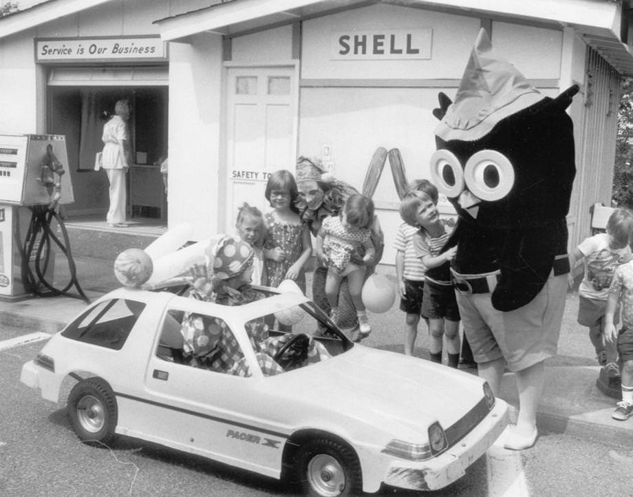 #16 Safety Town Opens – This summer’s installment of Safety Town opened at Azalea Mall yesterday, and among those on hand were Marcia Carr as Clyde the Clown (in car), Leigh Burke as Cupid the Clown, and Mike Martin as the owl.