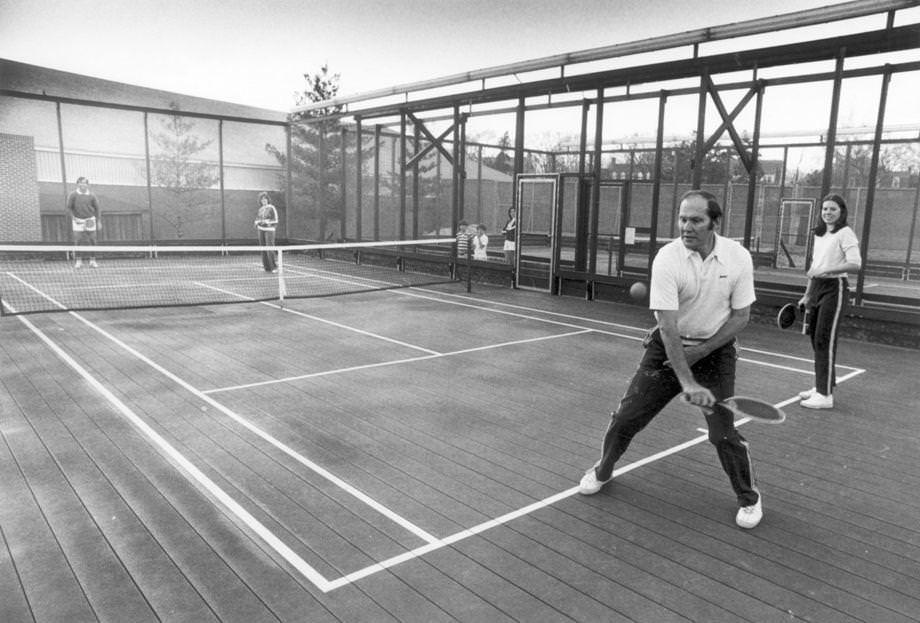 #19 Hal Burrows serves while partner Courtney Drake looks on at CCV’s platform tennis facility, 1978