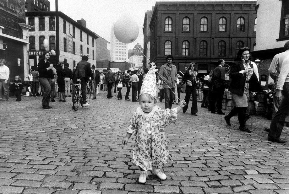 #57 Young reveler Christopher Gibbs held a balloon while thousands wandered Shockoe Slip in Richmond at the Great Pumpkin Party, 1976.