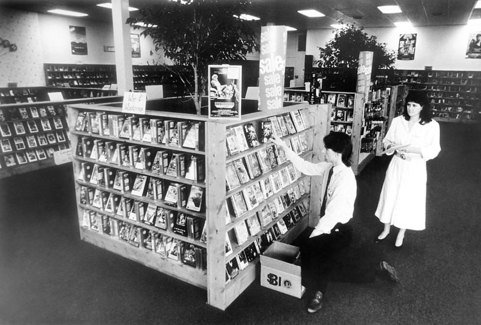 #10 Manager Cissy Travers (right) and assistant John Gurski organized the shelves at Video World, a video rental store on Robious Road in Chesterfield County, 1987