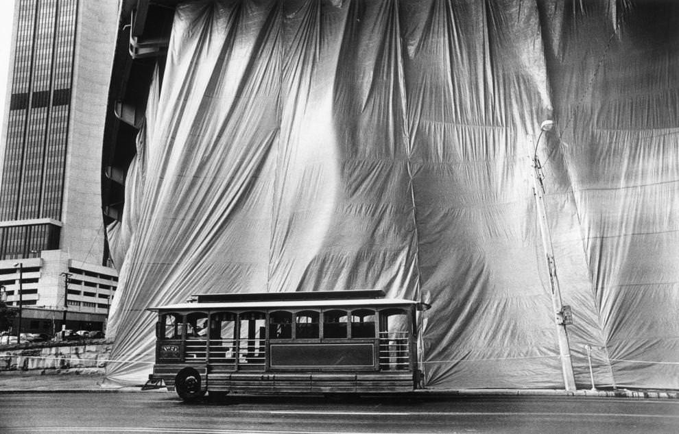 #77 A trolley passed by a large screen that protected passing vehicles from sandblasting and painting under Interstate 95 on East Main Street, 1988