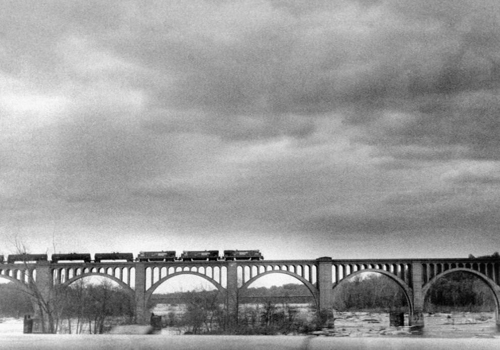 #17 Under dark skies, a freight train made a southbound crossing of the James River on the Seaboard System Railroad bridge downriver from the Powhite Parkway, 1986