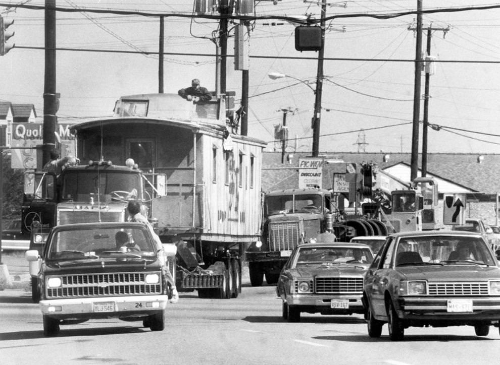 #117 An old wooden caboose was hauled by truck on West Broad Street en route to John B. Cary Elementary School in Richmond, 1981