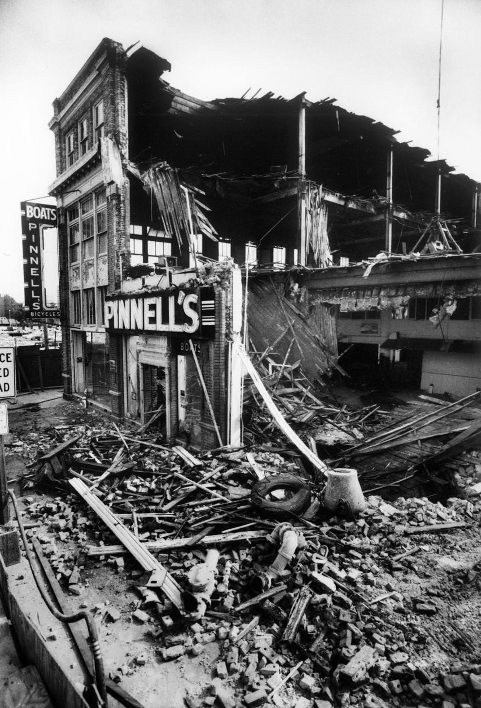 #24 A section of the former Pinnell’s boat and bicycle shop on lay in ruins after demolition the day before, 1982