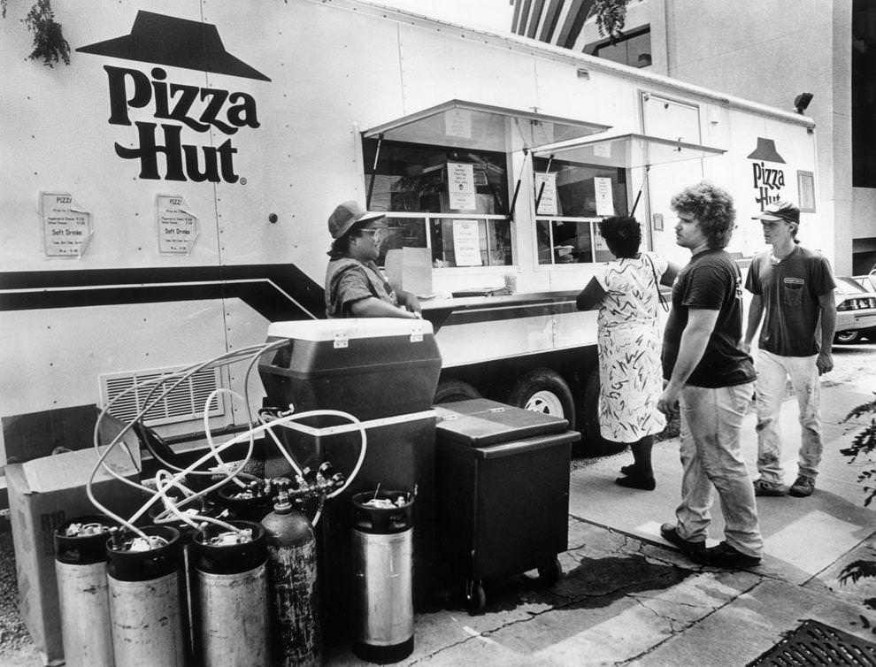 #67 Norma Ray (left) served beverages at a Pizza Hut trailer outside Main Street Centre in downtown Richmond, 1988