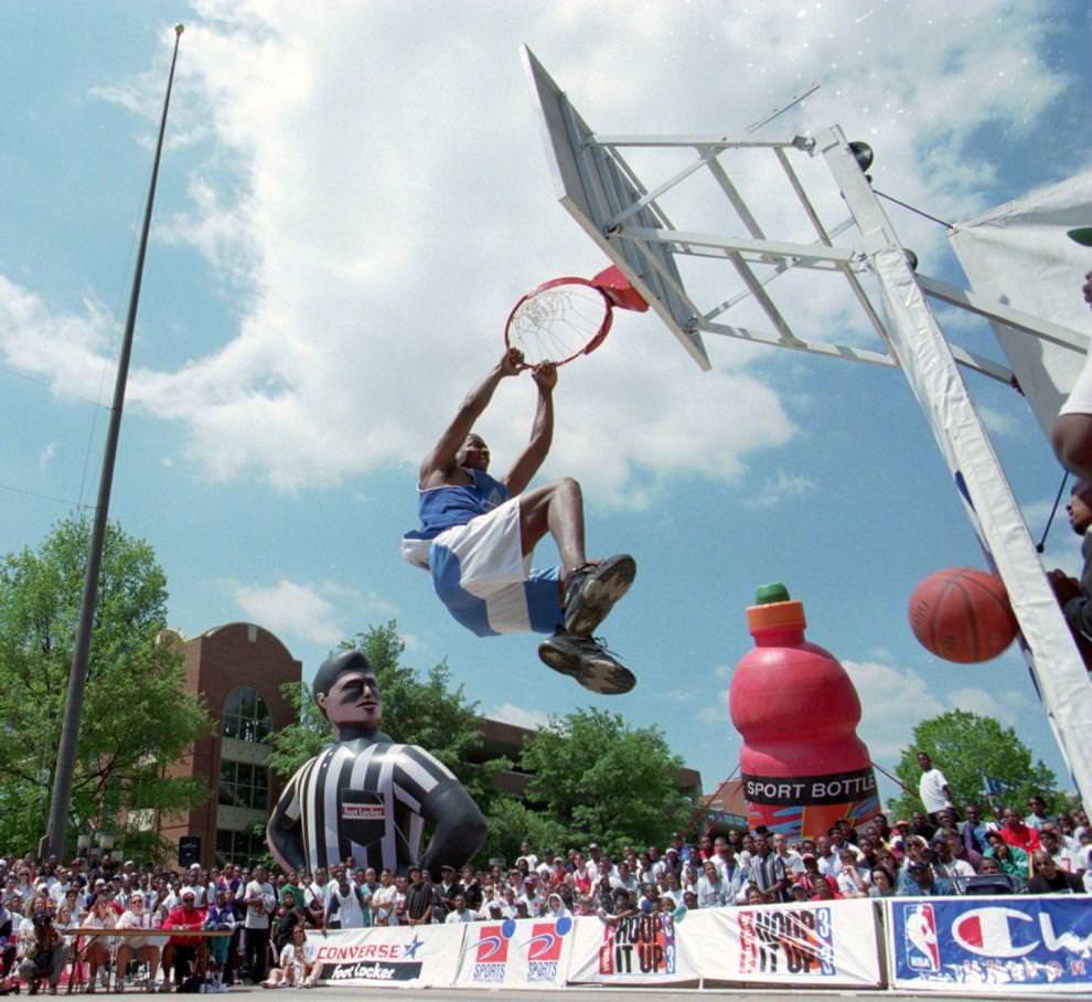 #1 Tracy ‘Supernintendo’ Turner of Silver Spring, MD. hangs onto the rim after a slam dunk in the Hoop it Up Slam Dunk Contest at Festival Park, 1995