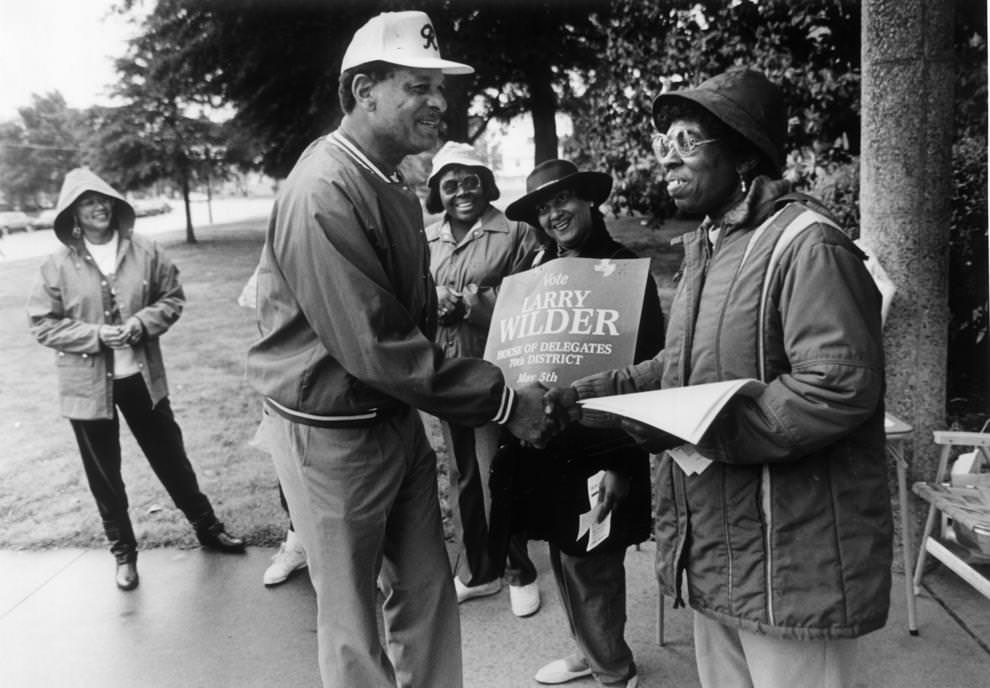 #49 Richmond Mayor Walter T. Kenney clasped the hand of Marian Brown yesterday outside Mosby Middle School, as supporters Sharon Menefee (center) and Laura Miles smiled their greetings, 1992