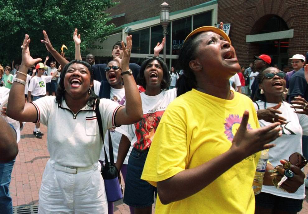 #57 After walking in the March for Jesus, Sandra Brown (left) and Marjilette Brown (in yellow) pray with hundreds of others in Festival Park, May 30, 1998.