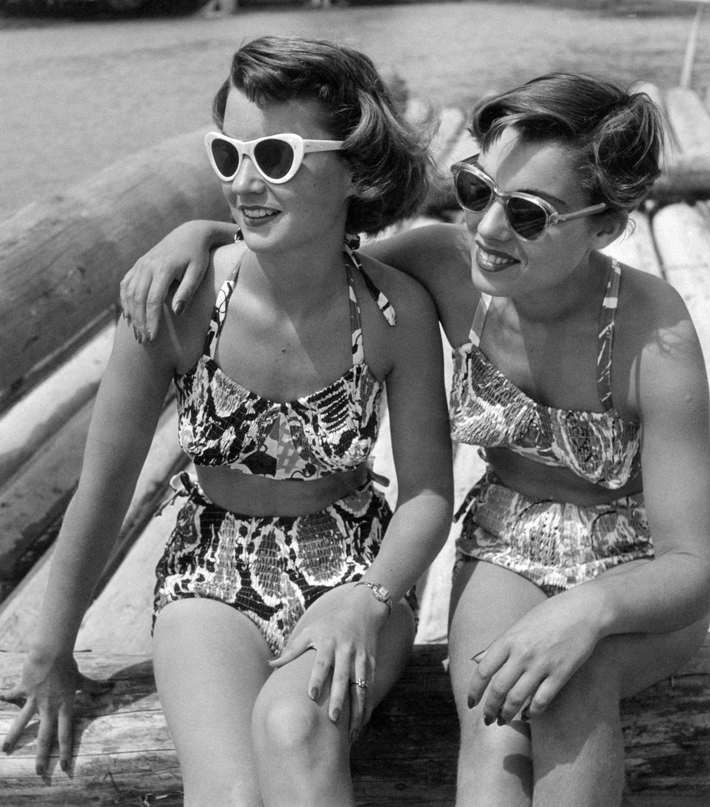 #42 Two girls in sunglasses and bikini hugging each other, 1950s.