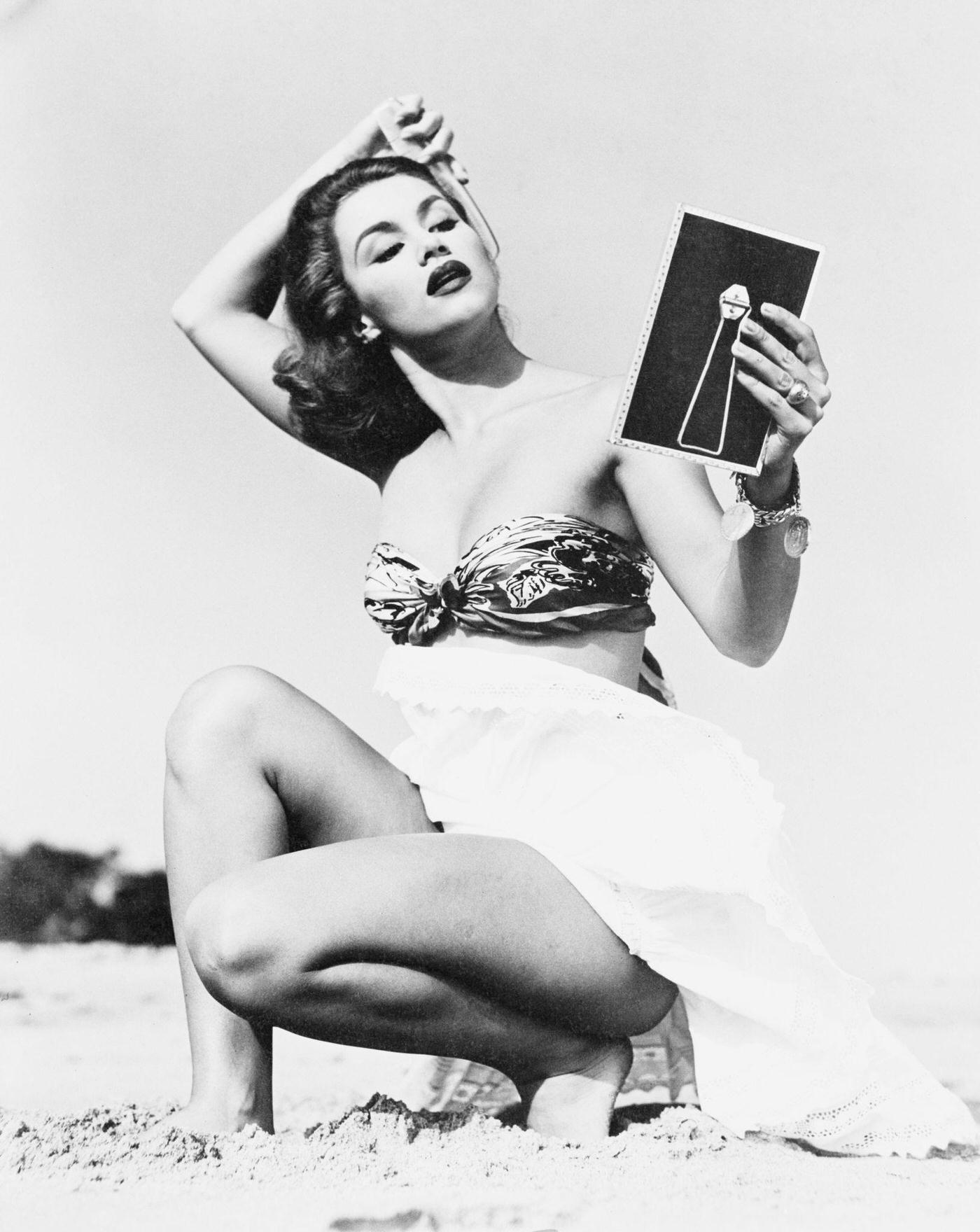 #54 Young woman brushing her hair on the beach, 1948.