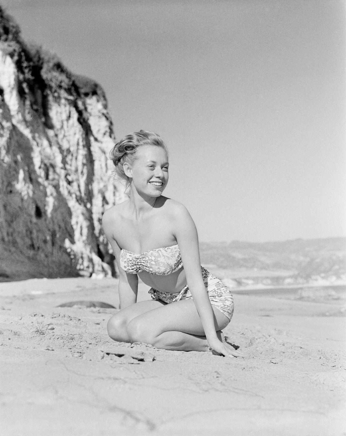 #55 Model Fran Cooper wearing a patterned bikini on the beach, 1948.