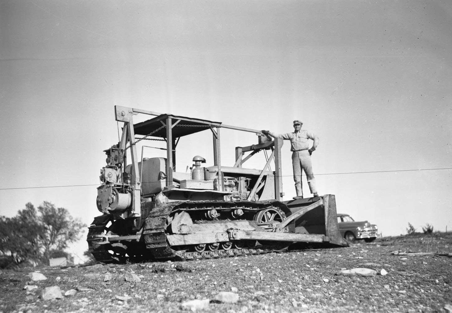 #61 Man Standing on Tractor in Field, 1950.