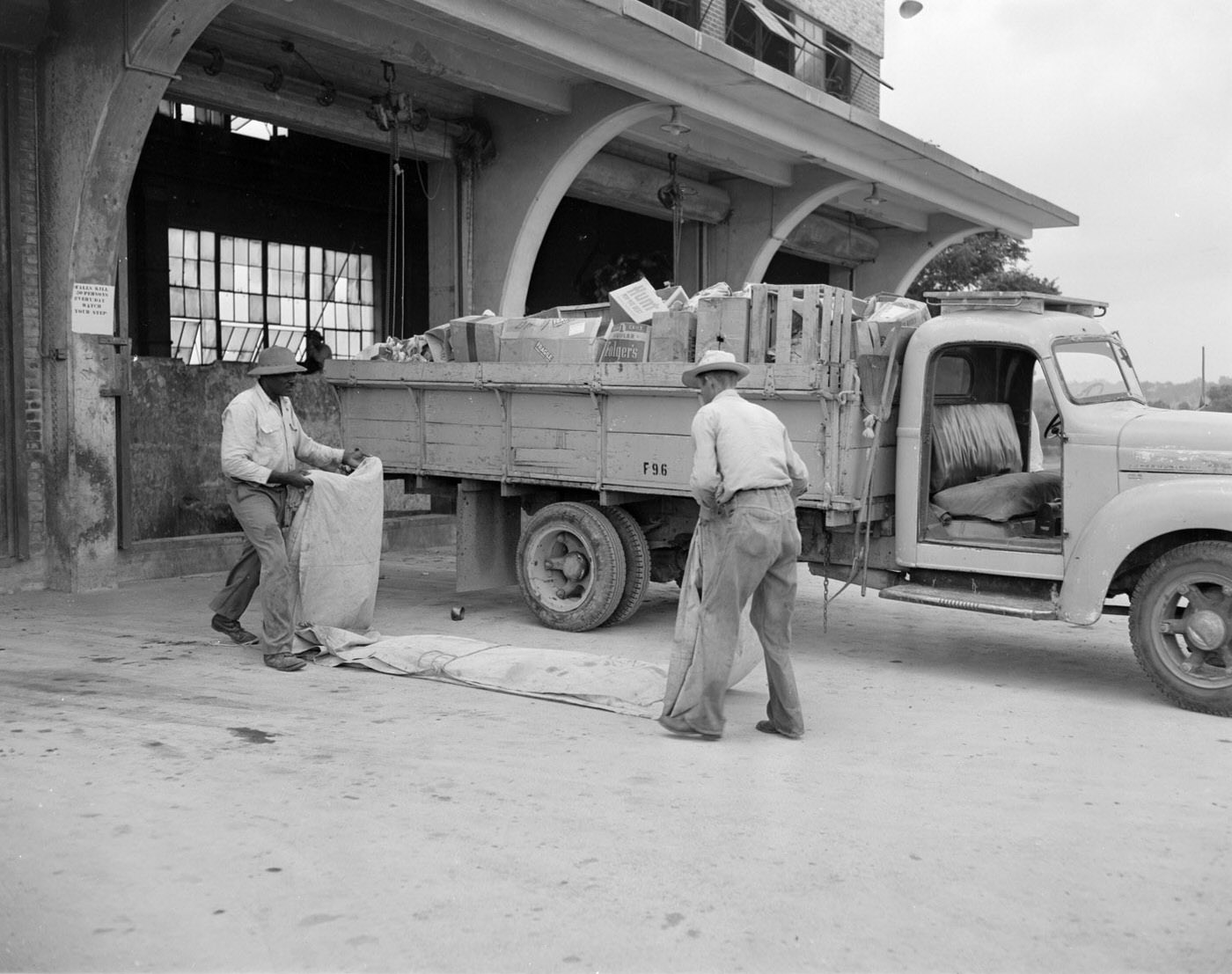 #123 Men Folding Drape by Sanitation Truck, 1953.