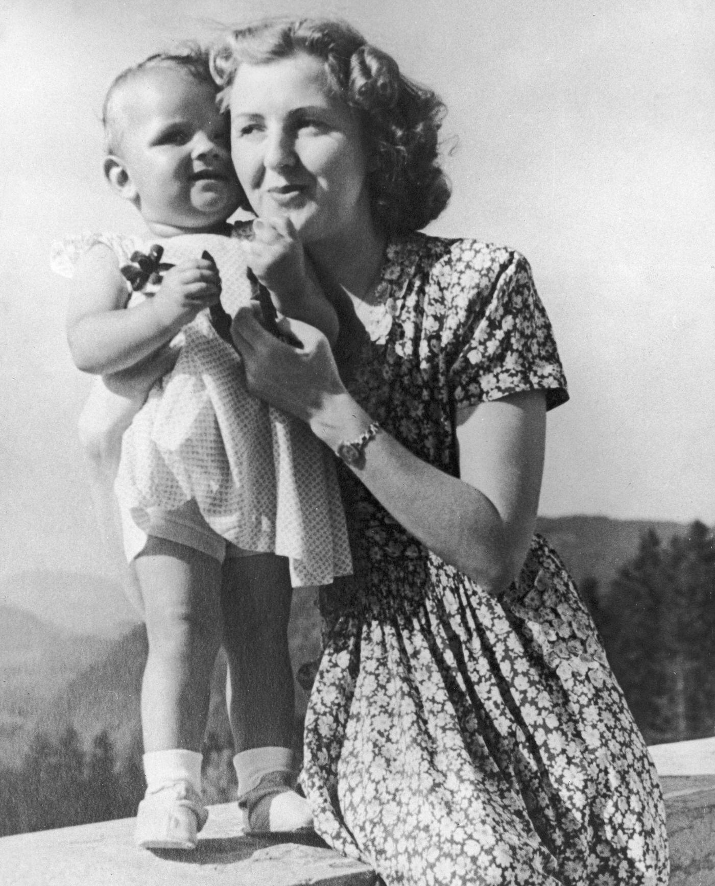 #22 Eva Braun poses on a terrace with an infant, still from a home movie taken by her sister, circa 1942