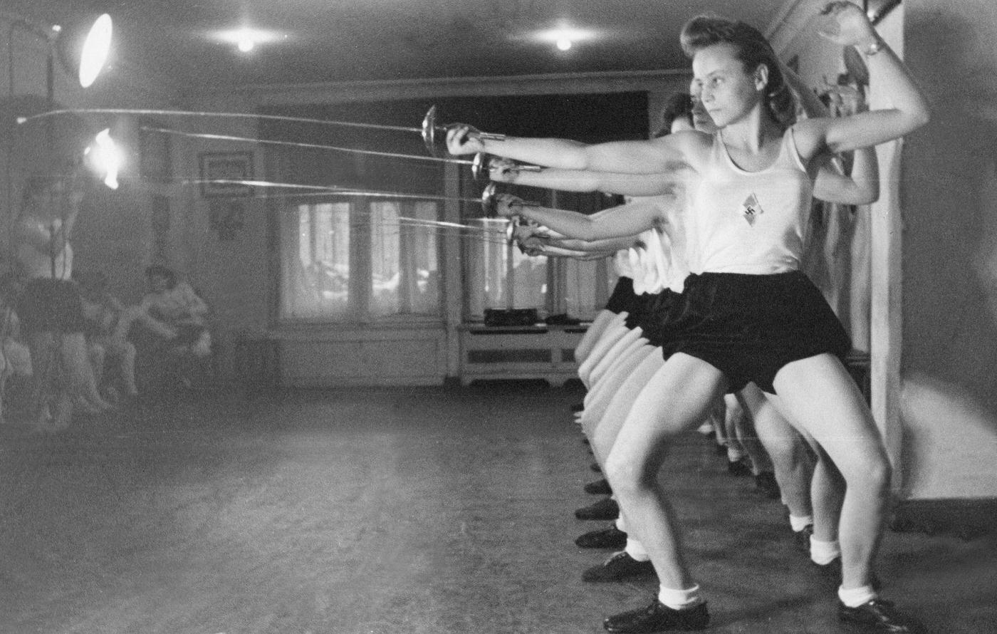 #109 Grain harvest in Germany: Young female farm hands bind freshly cut grain to sheaves.