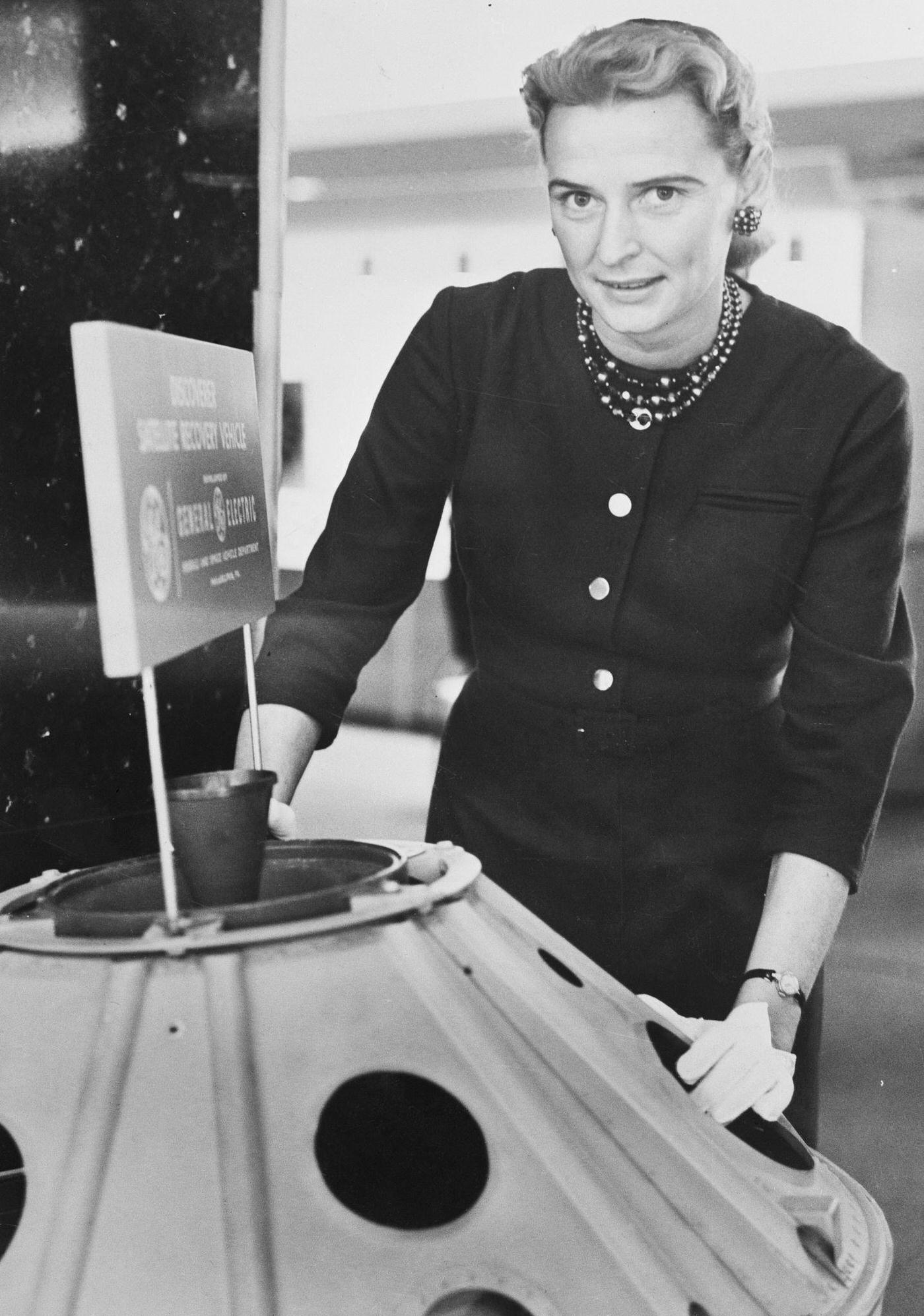 #6 Jerrie Cobb Standing Near Satellite Model, 1950s