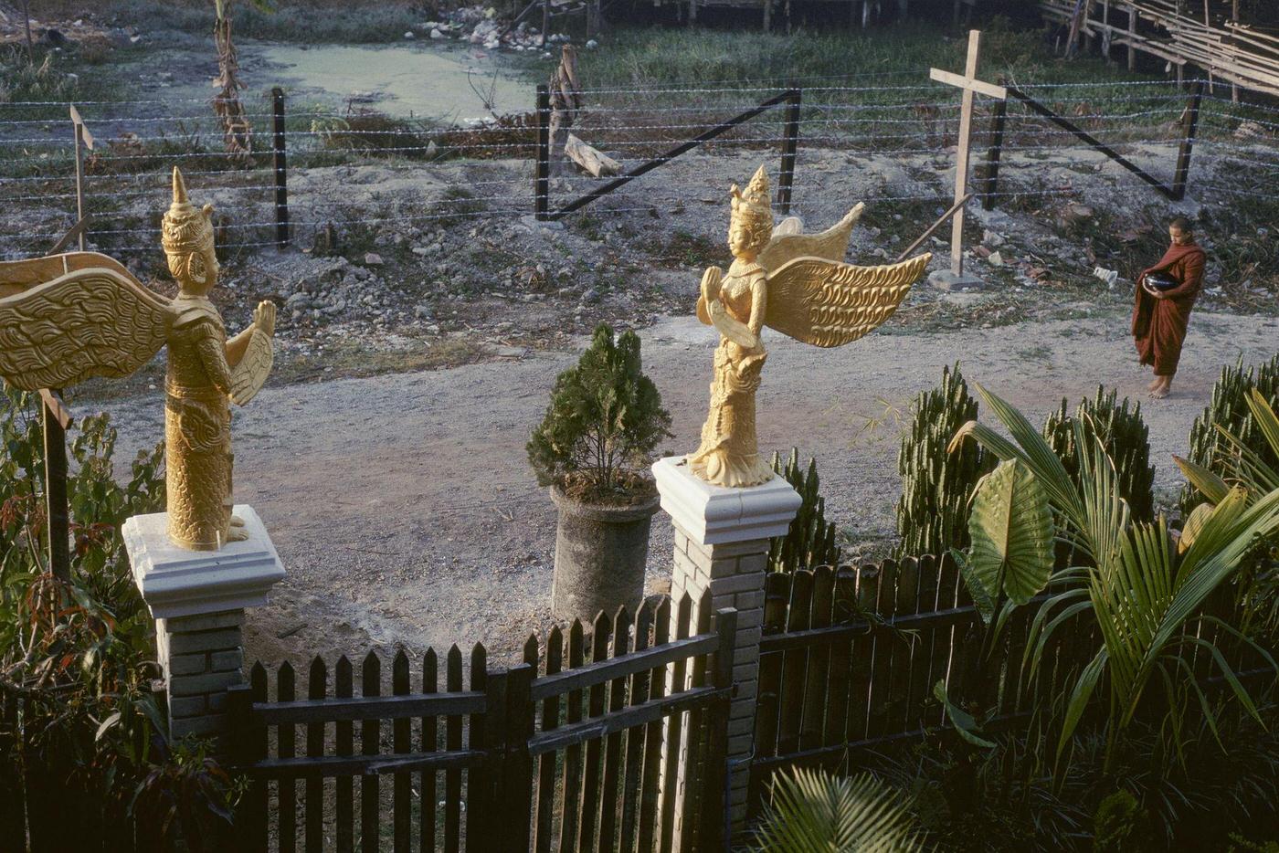 #59 Nyaung Shwe, Myanmar – Buddhist Monks Passing Statues of Angels, 1980s