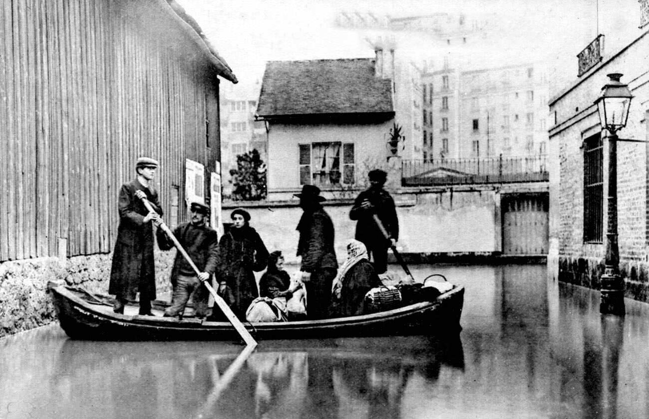#74 10th-century flooded Paris street with rowing boat, France, 1910.