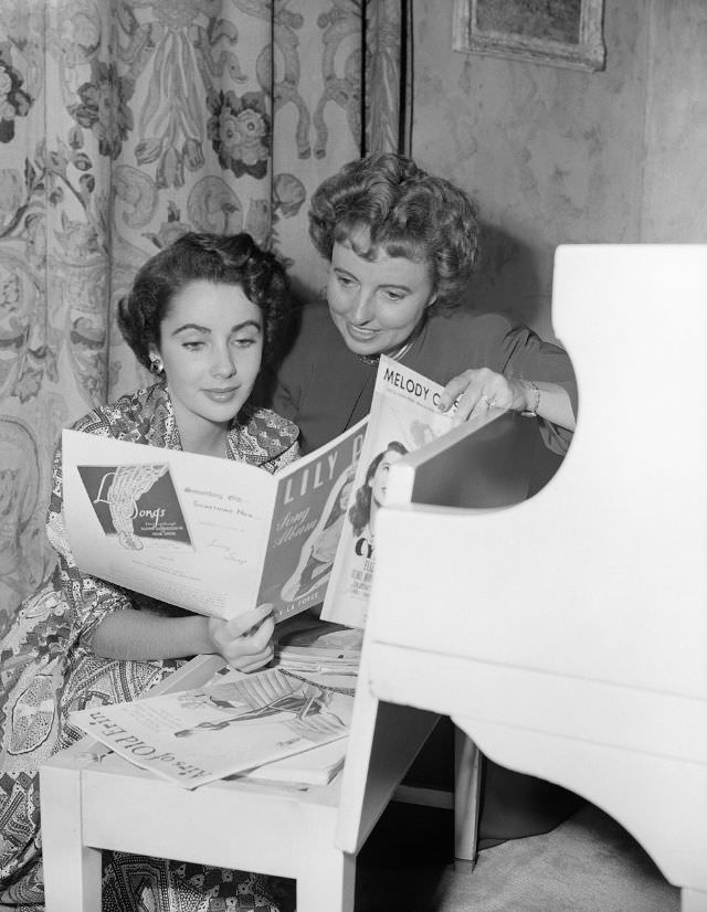 #11 Sara Sothern and her daughter Elizabeth Taylor look over sheet music at the piano in their Beverly Hills home, 1949