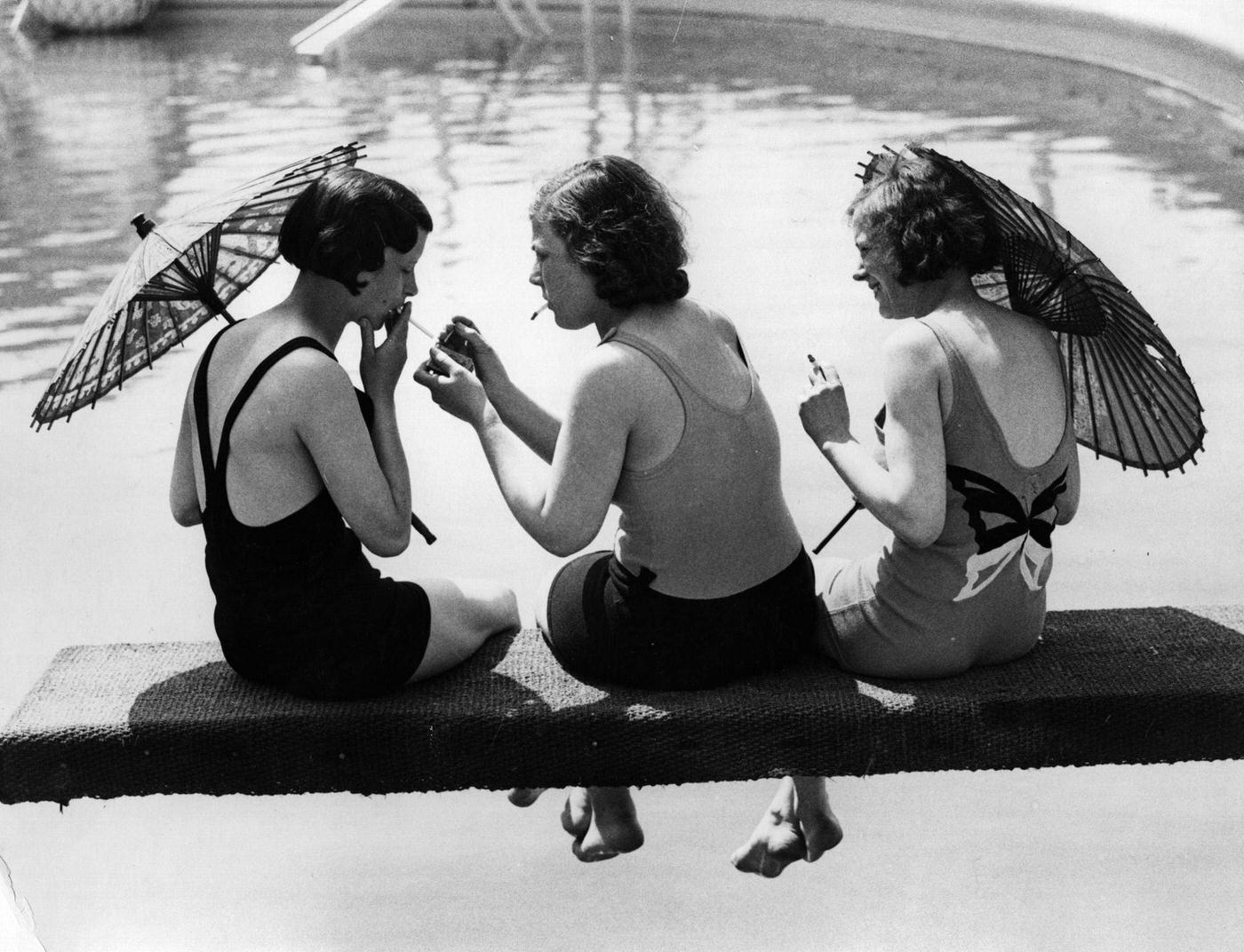 #43 A group of women light up their cigarettes while relaxing on a diving board at Cliftonville