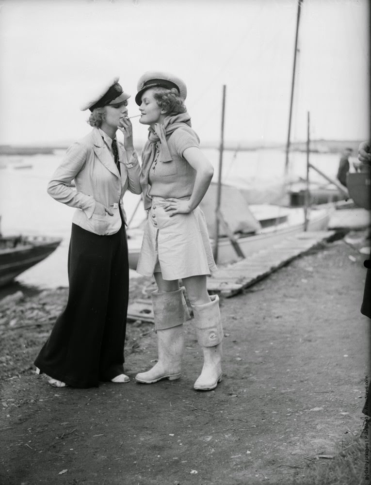 #12 Two women in yachting caps. One is lighting her cigarette from the others, 9th May 1936