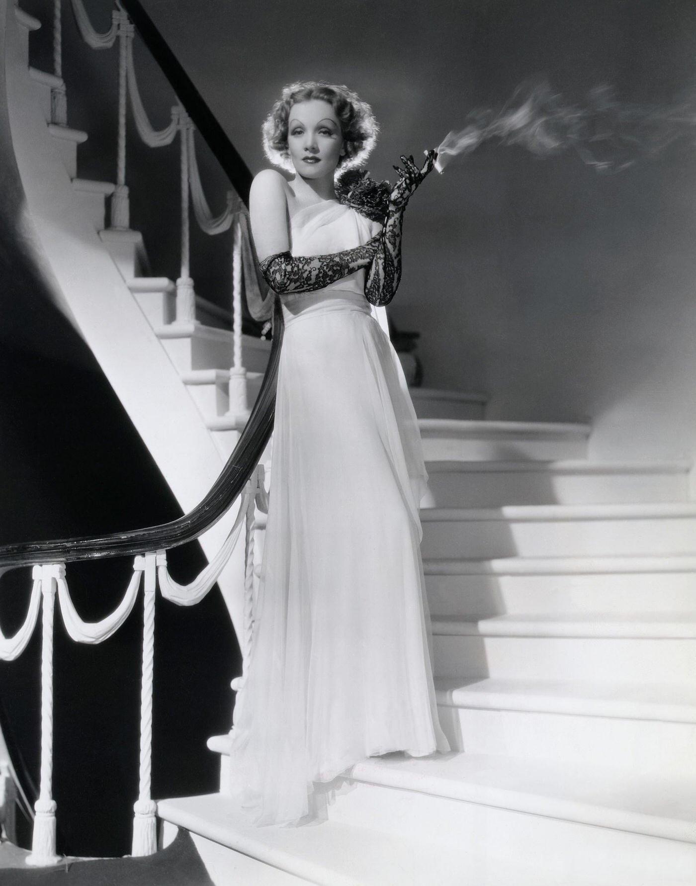 #64 Marlene Dietrich in a white chiffon evening gown designed by Travis Banton, 1935
