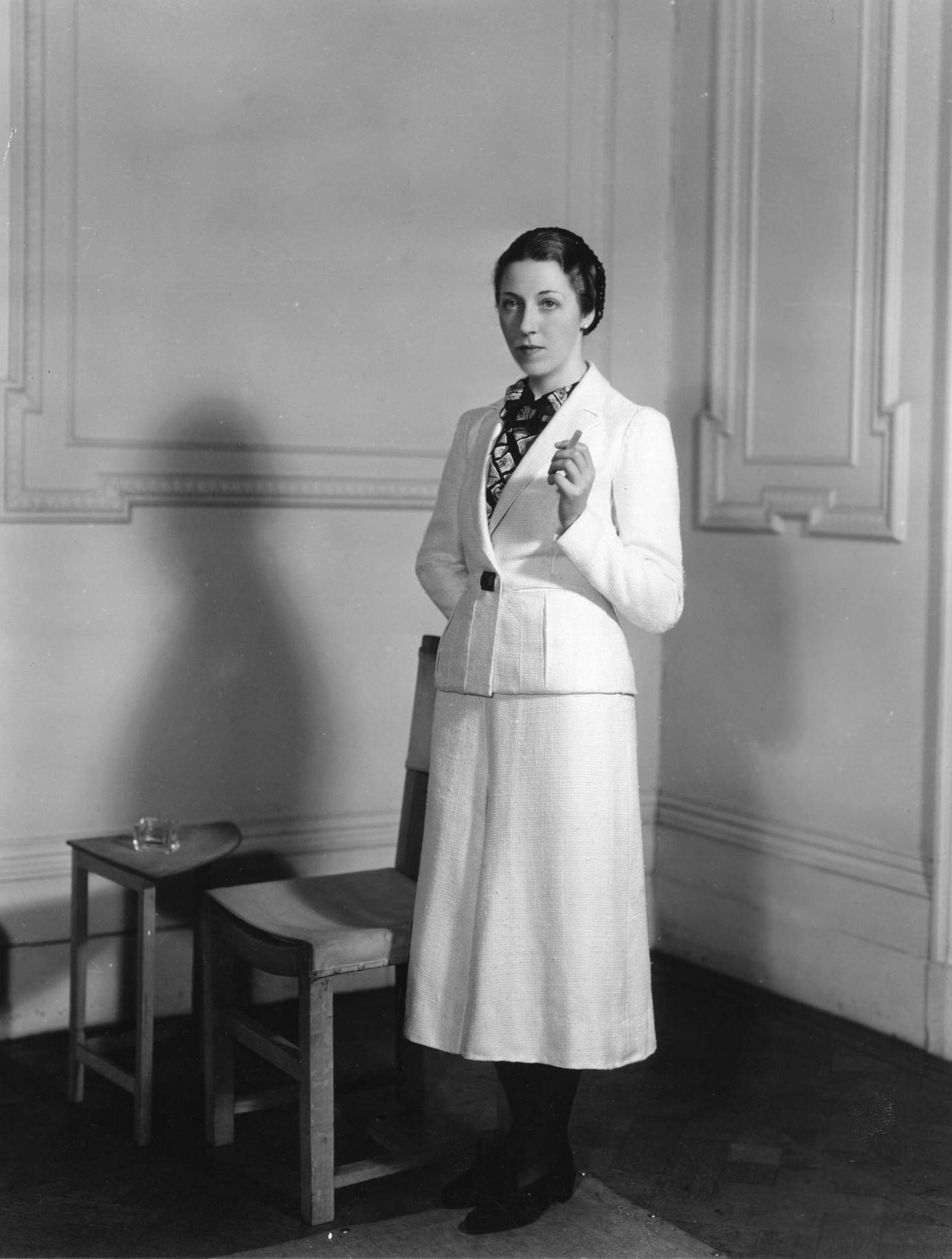 #68 English aviator Amy Mollison wearing a woollen suit designed by Madame Schiaparelli for her flight from London to Cape Town, 1936