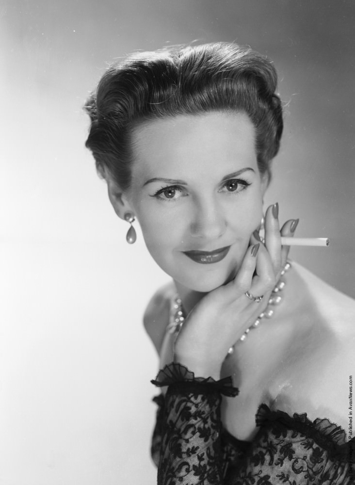 #5 A woman modeling a dress and smoking a cigarette. 23rd February 1953.