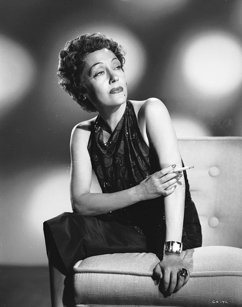 #31 American actress Gloria Swanson smoking a cigarette, circa 1950.
